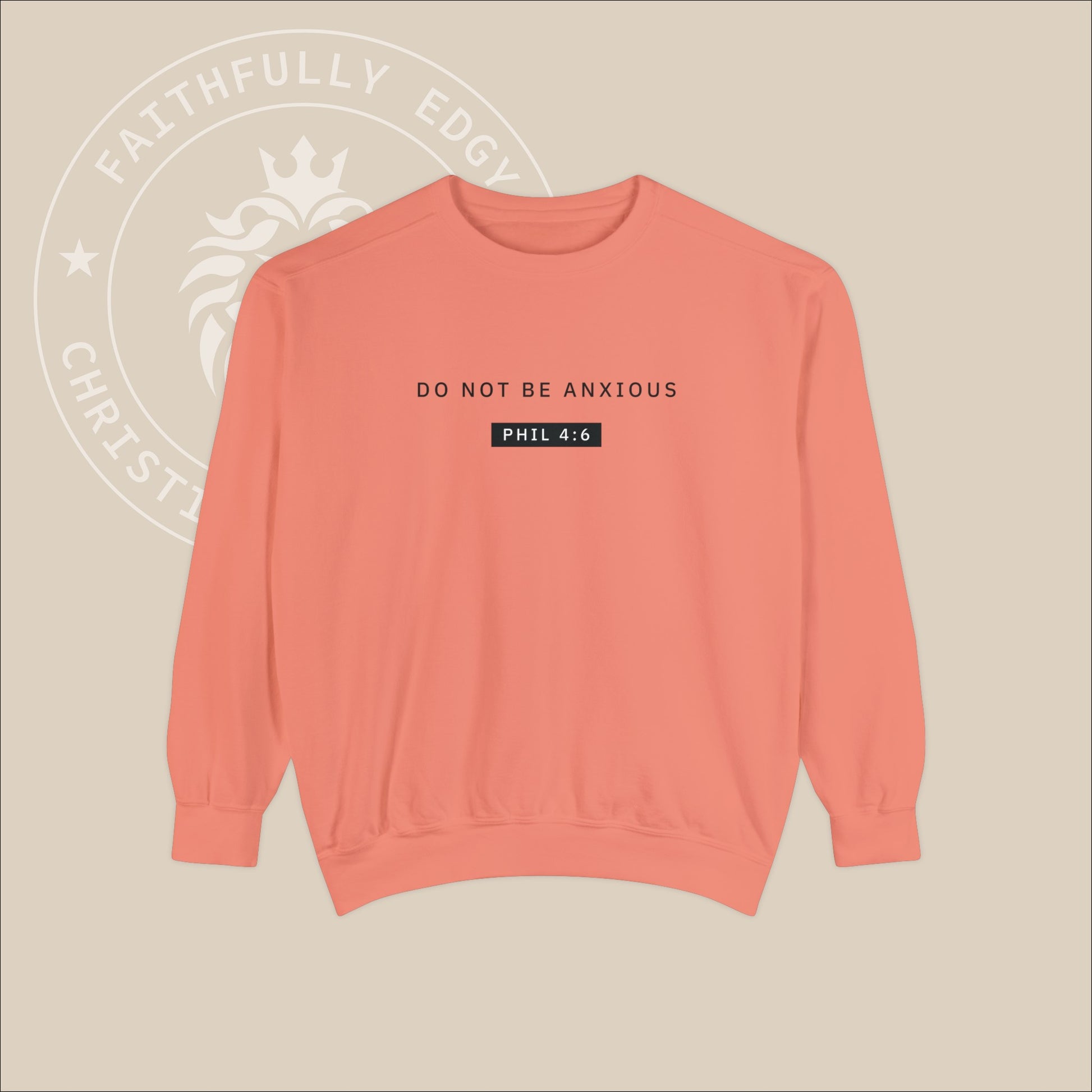 Peach crewneck sweater with black "Do not be anxious" print. 